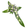 A solemn floral cross photographed on a clean white background from a slight overhead angle, each detail rendered with calm clarity. The cross is formed from broad, glossy tropical leaves - think Ti leaves - their deep green surfaces polished and veined to create a strong, structured silhouette for the horizontal and vertical arms. At the centre and running delicately along each arm sits a concentrated spray of soft, neutral blossoms: creamy ivory and pure white lisianthus with ruffled, layered petals and tender closed buds, intermingled with small, rounded white chrysanthemum sprays that add bright, cushiony texture. Sprays of tiny, star-like lavender or pale purple aster/limonium are threaded through the white cluster, offering a gentle, cooling contrast and small points of colour that draw the eye inward. Finer green fillers are woven through the blooms so the composition reads as both natural and carefully crafted, the waxy leaf surfaces set against the delicate, almost papery petals. The lighting is soft and even, a faint overhead glow that lifts the pale tones and leaves a tranquil, reverent mood - the kind of piece chosen for funerals, memorials, or church services to express mourning, respect, and quiet remembrance. The scent suggested by the arrangement is faint, green and slightly sweet rather than overpowering, like a sheltered garden at dawn. As a local florist's interpretation of a traditional Christian tribute, this cross balances strength and tenderness with classic sympathy colours and textures, suitable for laying at a graveside or for display at a service in Friern Barnet or nearby churches and community halls.